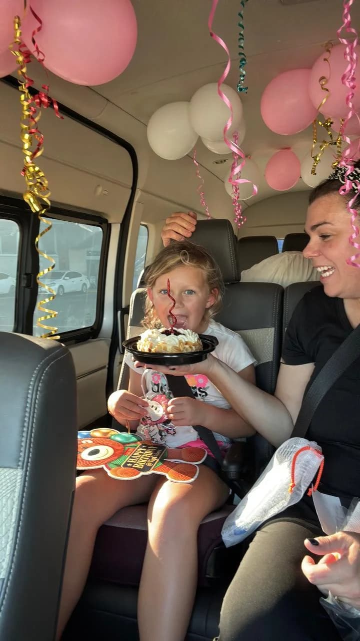 The birthday girl taking her first bite of cake inside the decorated van