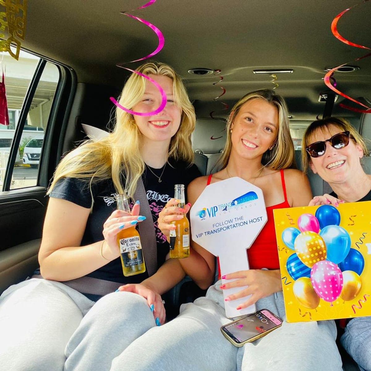 Birthday guests toasting in the van with balloons and streamers